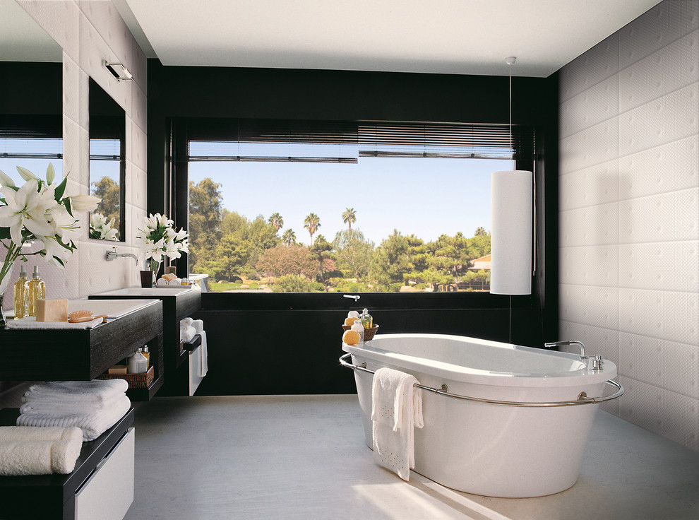Foto de cuarto de baño moderno con bañera exenta, paredes negras y ventanas