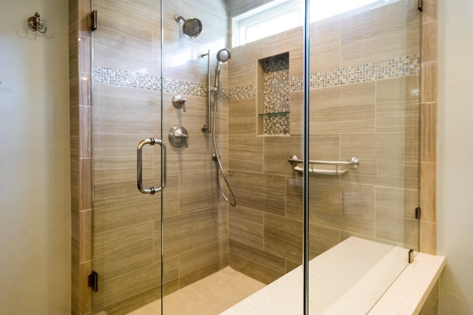 Modernes Badezimmer En Suite mit flächenbündigen Schrankfronten, dunklen Holzschränken, Eckdusche, beigen Fliesen, Porzellanfliesen, beiger Wandfarbe, Granit-Waschbecken/Waschtisch und Falttür-Duschabtrennung in San Diego