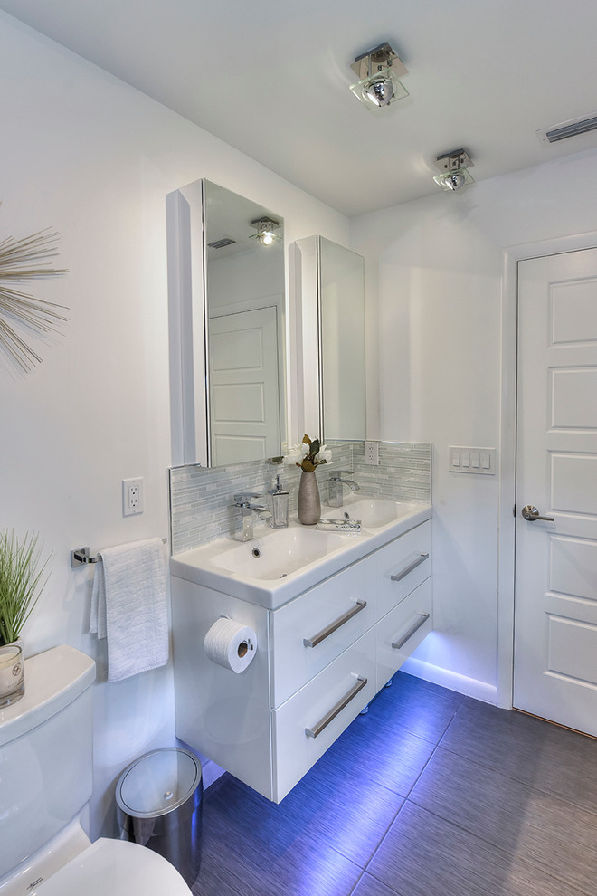 Esempio di una stanza da bagno padronale minimalista di medie dimensioni con ante lisce, ante bianche, WC a due pezzi, piastrelle grigie, piastrelle in ceramica, pareti bianche, pavimento con piastrelle in ceramica e top in marmo