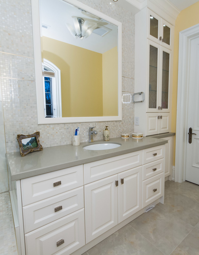 Idéer för att renovera ett mellanstort funkis badrum, med ett undermonterad handfat, luckor med upphöjd panel, vita skåp, bänkskiva i kvarts, ett badkar i en alkov, en dusch/badkar-kombination, en toalettstol med hel cisternkåpa, beige kakel, keramikplattor, gula väggar och klinkergolv i keramik