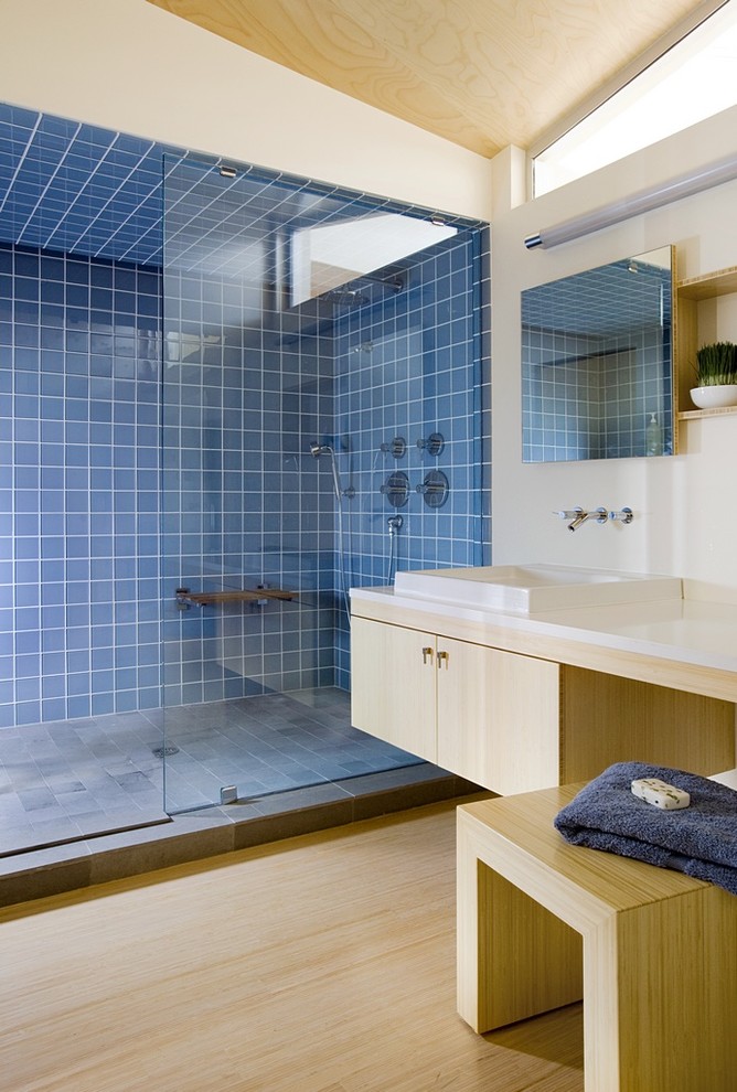 На фото: главная ванная комната в стиле модернизм с плоскими фасадами, светлыми деревянными фасадами, душем в нише, керамической плиткой, светлым паркетным полом, столешницей из искусственного камня, бежевым полом, душем с раздвижными дверями и белой столешницей с