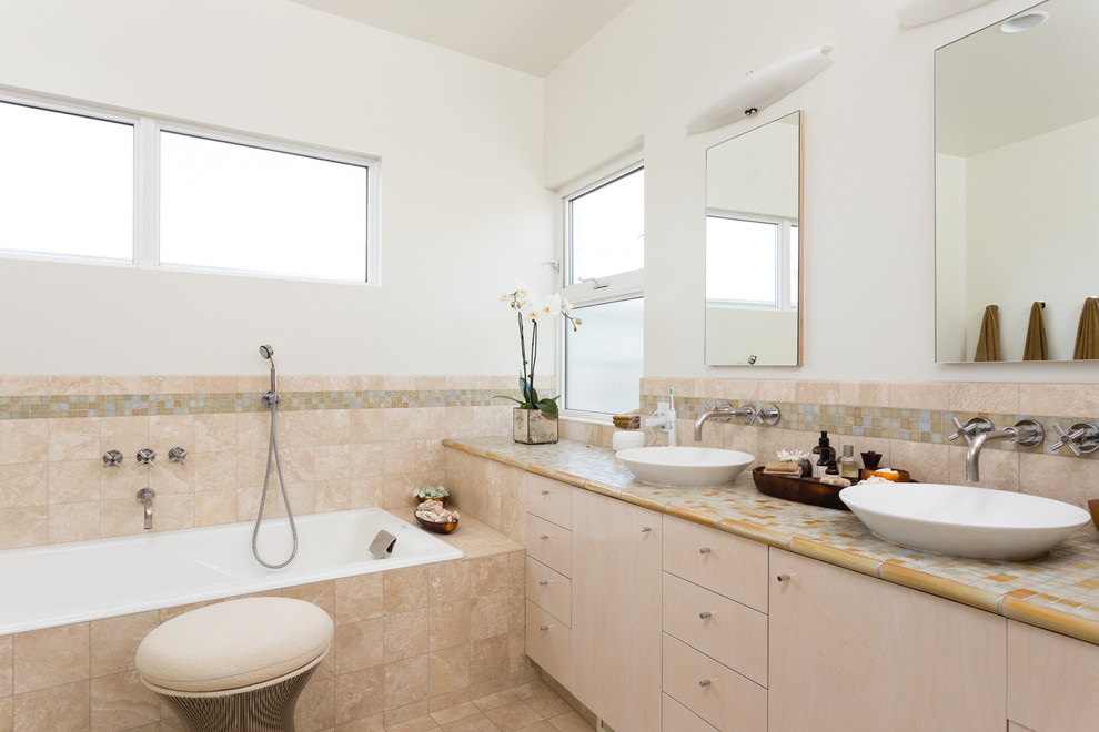 Пример оригинального дизайна: главная ванная комната среднего размера в стиле модернизм с плоскими фасадами, светлыми деревянными фасадами, накладной ванной, желтой плиткой и белыми стенами