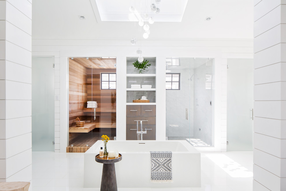 Maritimes Badezimmer mit freistehender Badewanne, Duschnische, weißer Wandfarbe, weißem Boden und Falttür-Duschabtrennung in Orange County