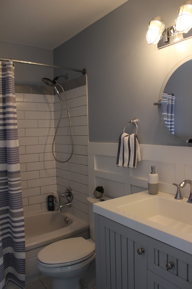 Стильный дизайн: главная ванная комната среднего размера в морском стиле с фасадами с выступающей филенкой, серыми фасадами, ванной в нише, душем над ванной, раздельным унитазом, белой плиткой, плиткой кабанчик, синими стенами, полом из керамогранита, монолитной раковиной, столешницей из искусственного камня, белым полом, шторкой для ванной и белой столешницей - последний тренд