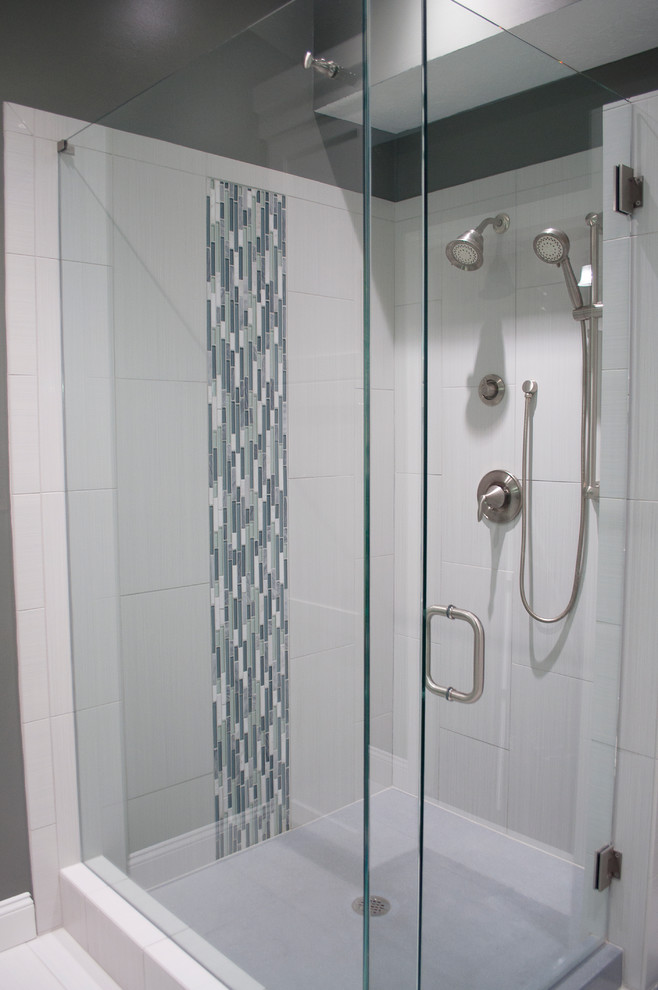 Cette image montre une salle d'eau minimaliste de taille moyenne avec un placard à porte shaker, des portes de placard blanches, une douche d'angle, un carrelage bleu, un carrelage gris, un carrelage vert, un carrelage blanc, des carreaux de porcelaine, un mur gris, un sol en carrelage de porcelaine, un lavabo encastré et un plan de toilette en granite.