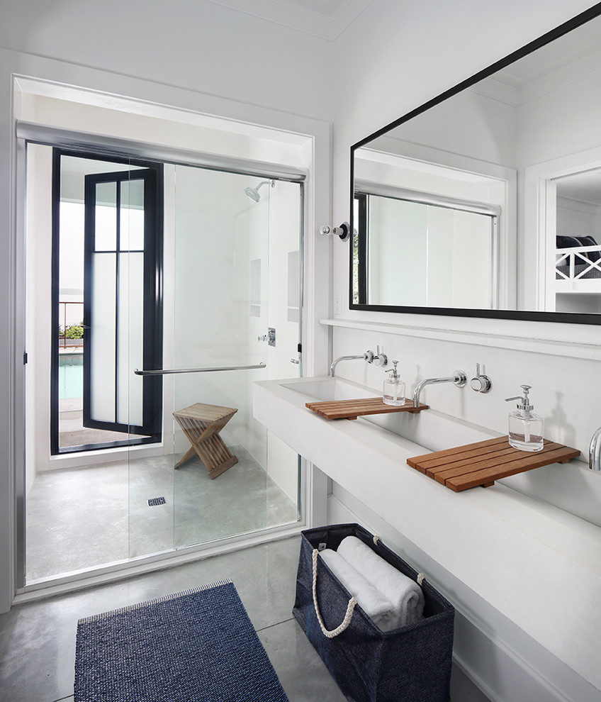 Modelo de cuarto de baño de estilo de casa de campo con ducha empotrada, paredes blancas, lavabo de seno grande, suelo gris, ducha con puerta corredera y suelo de cemento