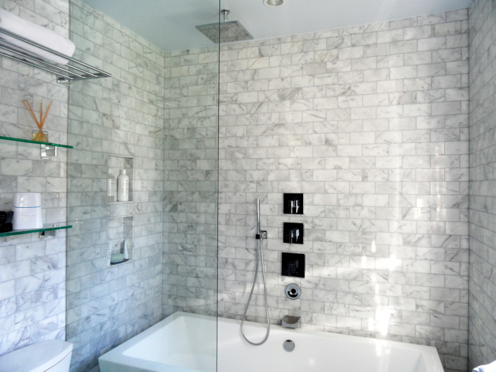 Idéer för ett modernt en-suite badrum, med vita skåp, marmorbänkskiva, ett fristående badkar, stenkakel och klinkergolv i porslin