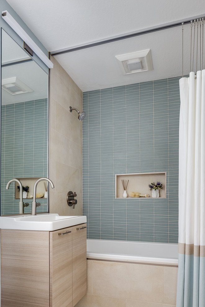 Exempel på ett litet badrum, med släta luckor, skåp i ljust trä, ett platsbyggt badkar, en dusch/badkar-kombination, en toalettstol med hel cisternkåpa, blå kakel, keramikplattor, beige väggar, ett integrerad handfat, bänkskiva i akrylsten och dusch med duschdraperi