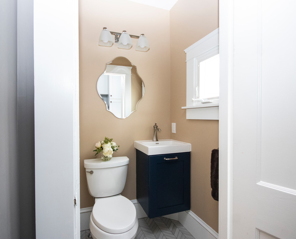 Exemple d'une petite salle d'eau moderne avec un placard à porte plane, des portes de placard bleues, WC séparés, un mur beige, un sol en carrelage de porcelaine, un lavabo suspendu, un sol gris et un plan de toilette blanc.