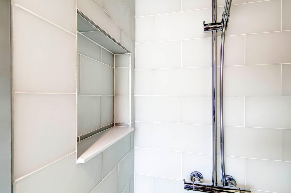 Exempel på ett mellanstort modernt badrum, med släta luckor, skåp i ljust trä, ett platsbyggt badkar, en dusch/badkar-kombination, en toalettstol med separat cisternkåpa, vit kakel, tunnelbanekakel, vita väggar, klinkergolv i keramik, ett integrerad handfat och bänkskiva i akrylsten