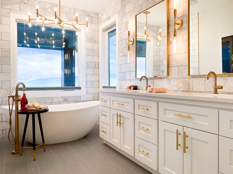 Transitional master white tile gray floor freestanding bathtub photo in Seattle with shaker cabinets, white cabinets, an undermount sink and white countertops