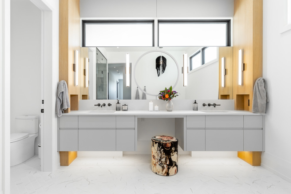 Foto de cuarto de baño doble y flotante actual con armarios con paneles lisos, puertas de armario grises, lavabo bajoencimera, suelo blanco y encimeras blancas