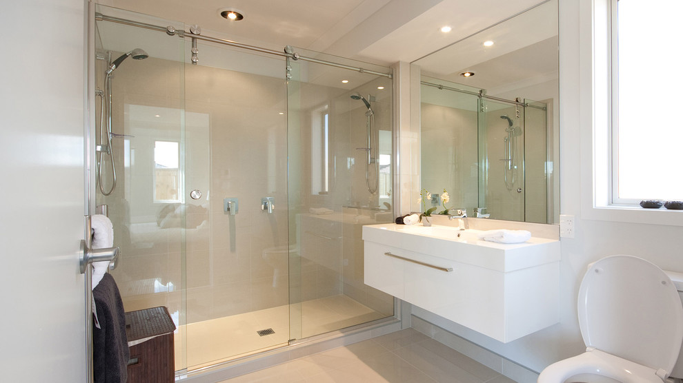 Ispirazione per una stanza da bagno padronale design di medie dimensioni con doccia doppia, WC monopezzo, pareti bianche, pavimento con piastrelle in ceramica e lavabo integrato