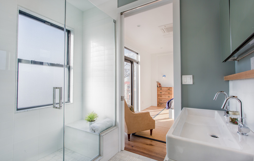 Inredning av ett modernt mellanstort badrum med dusch, med grå väggar, dusch med gångjärnsdörr, en hörndusch, vit kakel, tunnelbanekakel, klinkergolv i keramik, ett avlångt handfat och vitt golv