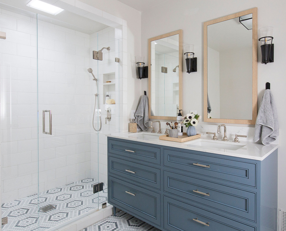 Источник вдохновения для домашнего уюта: большая главная ванная комната в стиле неоклассика (современная классика) с синими фасадами, душем в нише, белой плиткой, плиткой кабанчик, полом из мозаичной плитки, врезной раковиной, столешницей из искусственного кварца, разноцветным полом, душем с распашными дверями, белой столешницей, тумбой под две раковины, напольной тумбой и фасадами с декоративным кантом