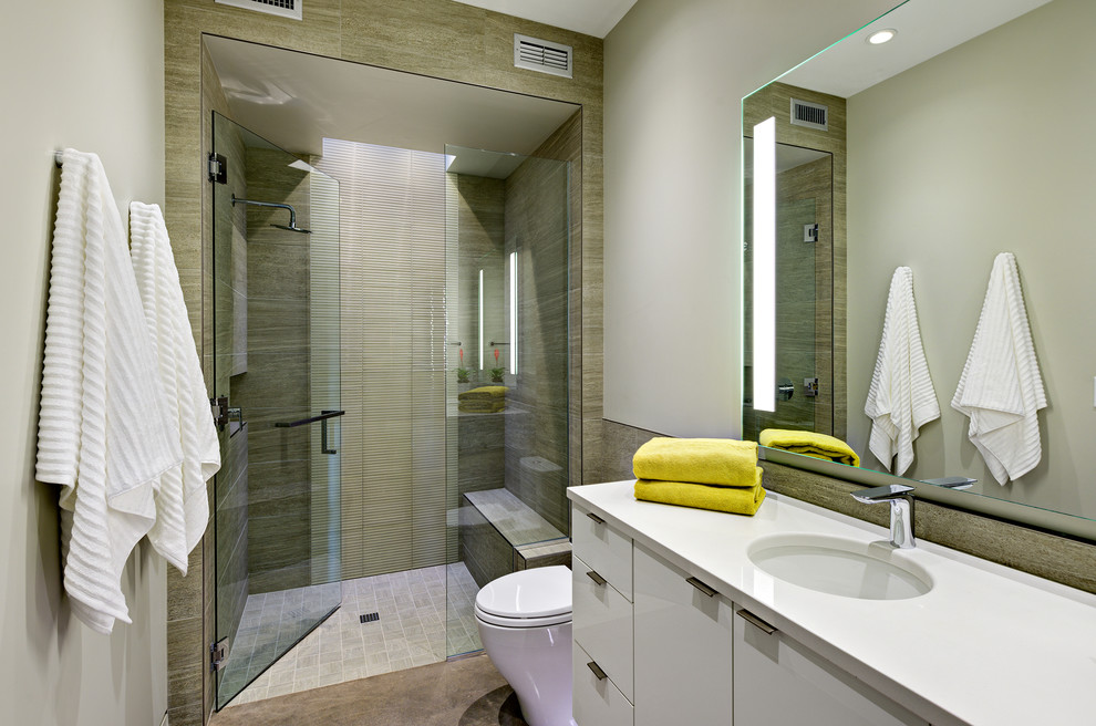Alcove shower - mid-sized contemporary 3/4 beige tile and porcelain tile concrete floor and gray floor alcove shower idea in Salt Lake City with flat-panel cabinets, white cabinets, a one-piece toilet, beige walls, a vessel sink, quartz countertops and a hinged shower door