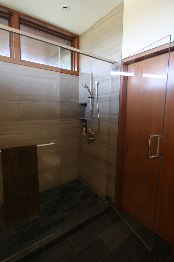 Design ideas for a medium sized modern ensuite bathroom in San Francisco with open cabinets, dark wood cabinets, a corner shower, a one-piece toilet, multi-coloured tiles, pebble tiles, beige walls, dark hardwood flooring, a submerged sink and solid surface worktops.