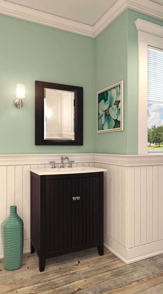 Cette photo montre une salle de bain bord de mer en bois foncé avec un lavabo intégré, un placard à porte affleurante, un plan de toilette en surface solide, un mur bleu et parquet clair.