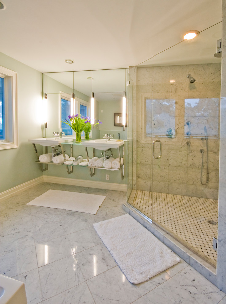 チャールストンにある広いモダンスタイルのおしゃれな浴室 (置き型浴槽、コーナー設置型シャワー、ベージュのタイル、壁付け型シンク、ガラスの洗面台、白い床、石タイル、青い壁、大理石の床、開き戸のシャワー) の写真