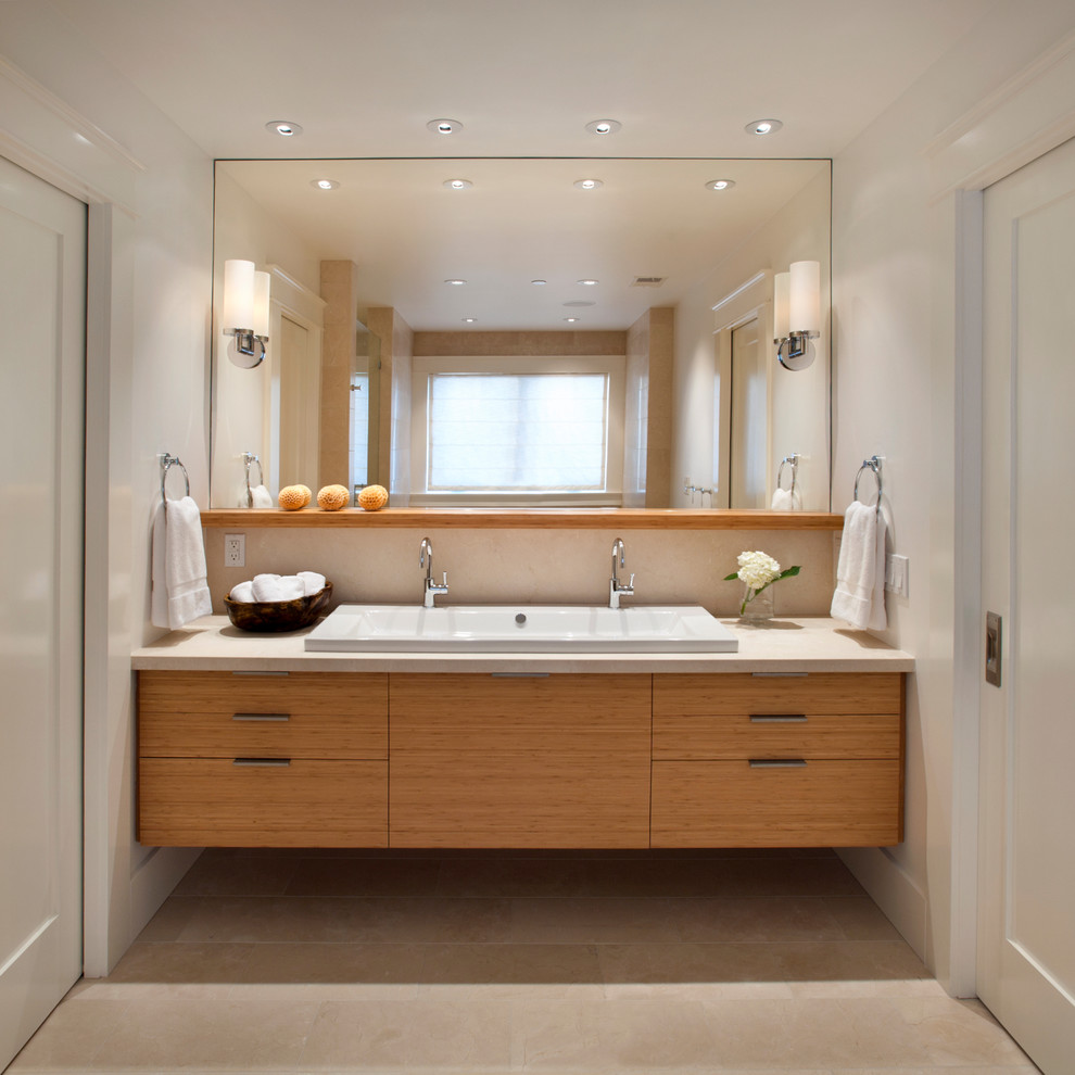 Example of a trendy limestone floor bathroom design in San Francisco with a trough sink and marble countertops
