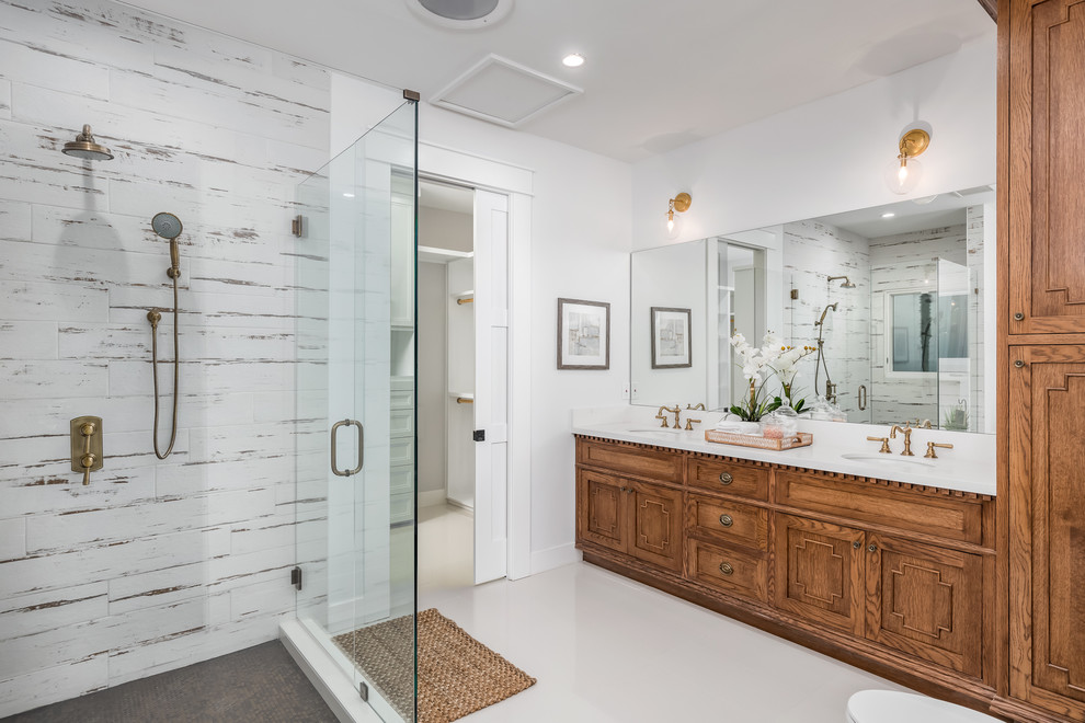 サンディエゴにあるトラディショナルスタイルのおしゃれな浴室 (中間色木目調キャビネット、コーナー設置型シャワー、白い壁、アンダーカウンター洗面器、白い床、開き戸のシャワー、白い洗面カウンター) の写真