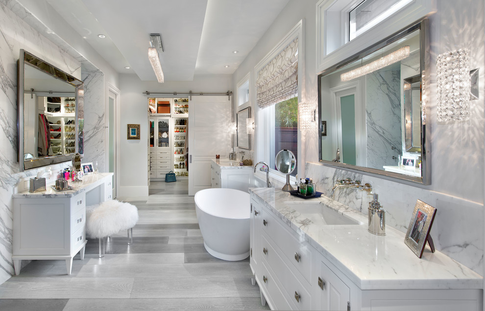 На фото: главная ванная комната в классическом стиле с врезной раковиной, белыми фасадами, отдельно стоящей ванной, белыми стенами, фасадами с выступающей филенкой и окном с