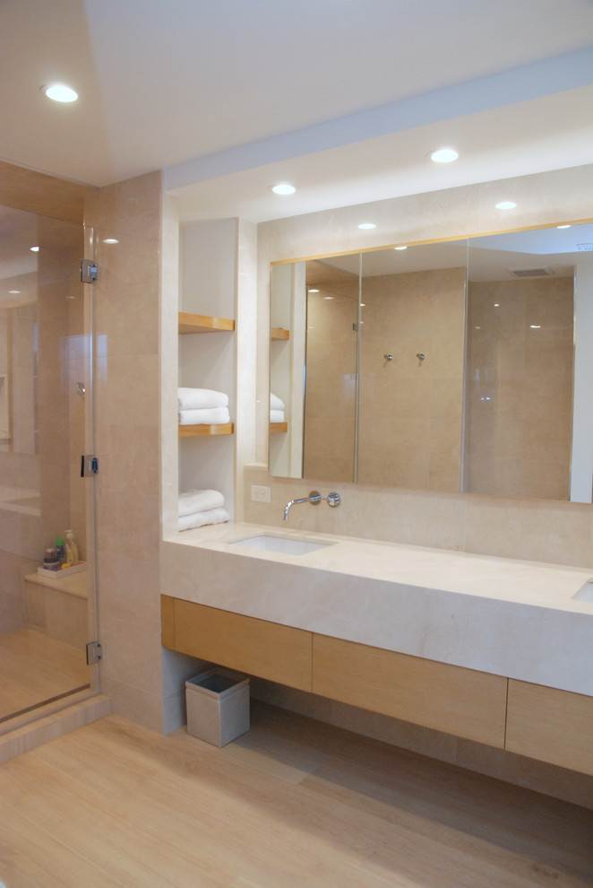 This is an example of a large modern ensuite bathroom in New York with flat-panel cabinets, light wood cabinets, an alcove shower, beige tiles, light hardwood flooring, a submerged sink, a hinged door, beige worktops, a shower bench, double sinks, a floating vanity unit and a coffered ceiling.