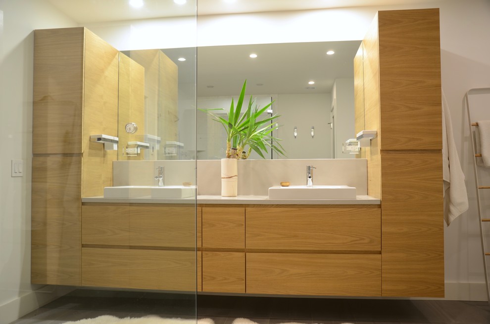 Пример оригинального дизайна: большая главная ванная комната в стиле модернизм с плоскими фасадами, светлыми деревянными фасадами, отдельно стоящей ванной, душем без бортиков, серой плиткой, каменной плиткой, белыми стенами, полом из керамогранита, настольной раковиной, столешницей из бетона и серым полом