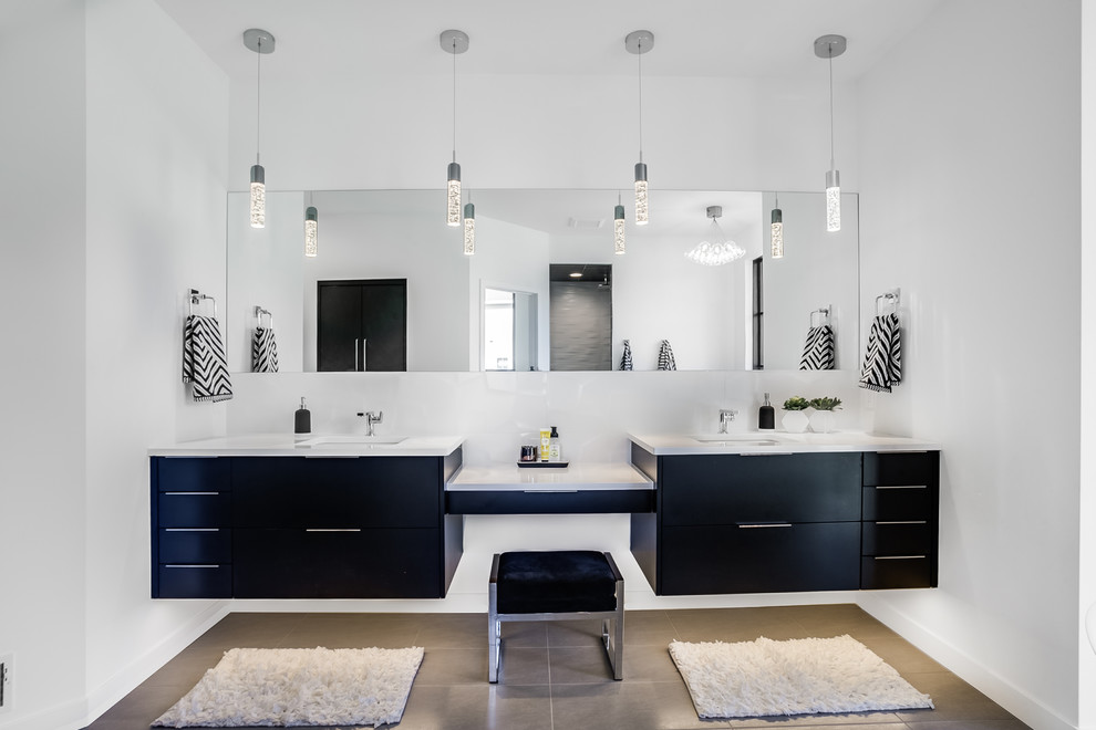 This is an example of a large contemporary ensuite bathroom in Grand Rapids with flat-panel cabinets, black cabinets, a freestanding bath, a walk-in shower, a two-piece toilet, white tiles, white walls, a submerged sink, quartz worktops, grey floors and an open shower.
