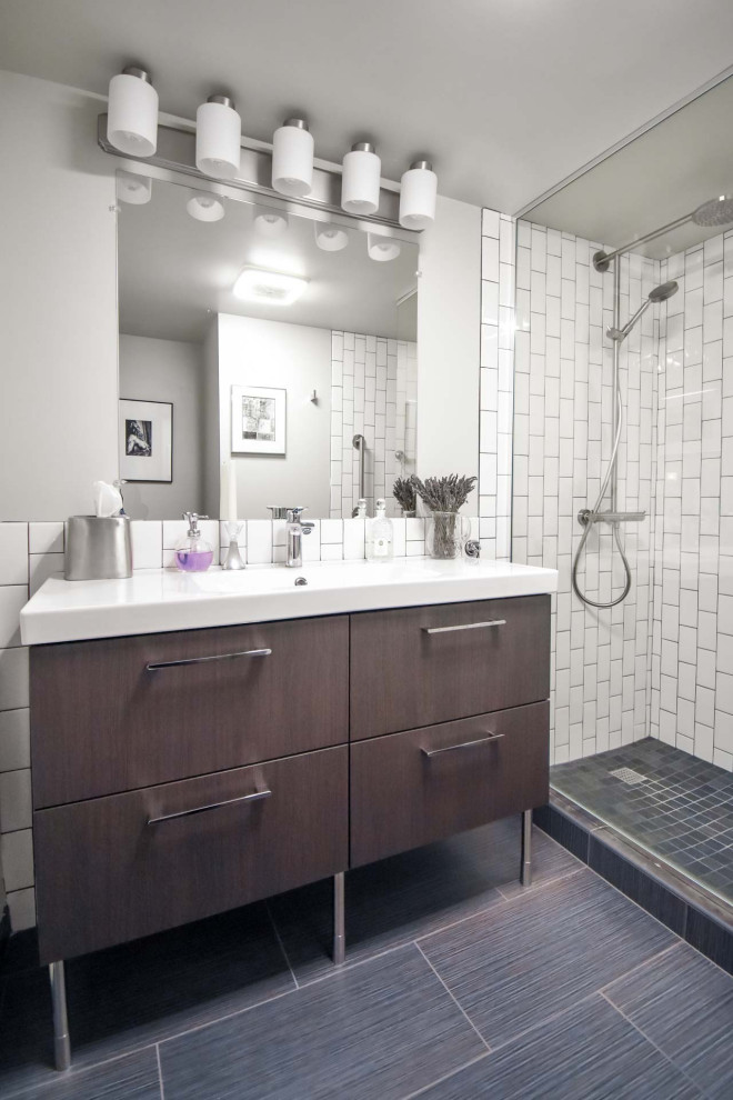 На фото: маленькая ванная комната в стиле модернизм с плоскими фасадами, коричневыми фасадами, душем в нише, раздельным унитазом, белой плиткой, плиткой кабанчик, серыми стенами, полом из керамической плитки, душевой кабиной, монолитной раковиной, черным полом, открытым душем, белой столешницей, нишей, тумбой под одну раковину и напольной тумбой для на участке и в саду