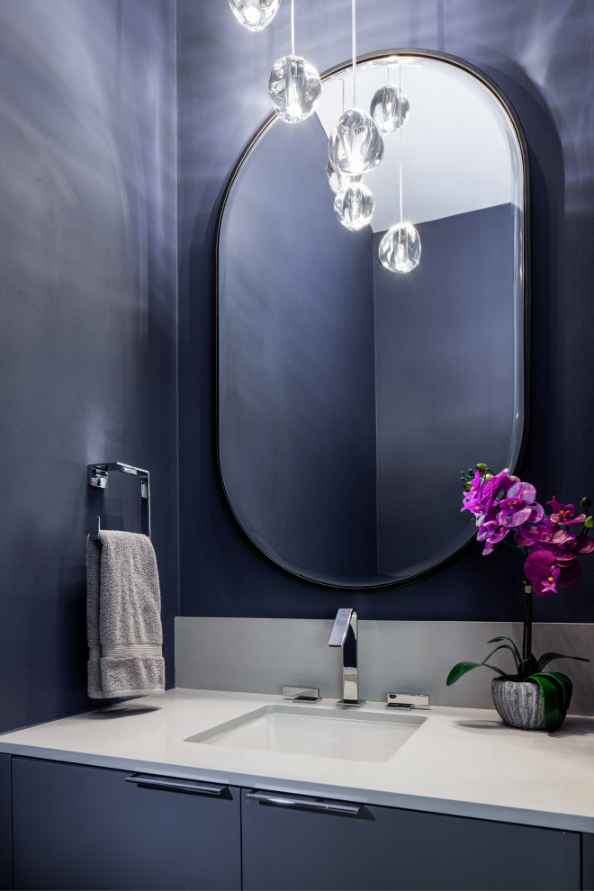 Cette image montre une petite salle de bain design avec un placard à porte plane, des portes de placard grises, WC séparés, un mur bleu, un sol en carrelage de porcelaine, un lavabo encastré, un plan de toilette en quartz modifié, un sol gris, une cabine de douche à porte coulissante, un plan de toilette gris, des toilettes cachées, meuble simple vasque et meuble-lavabo encastré.