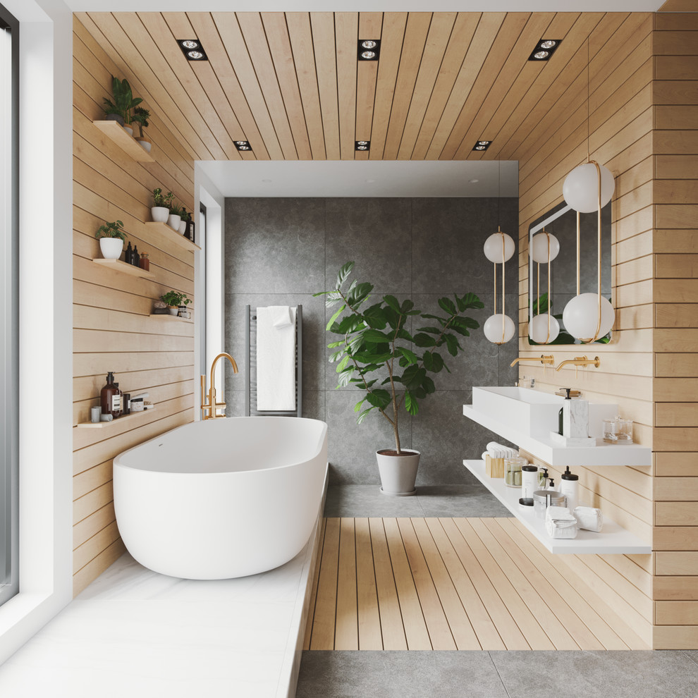 Modern inredning av ett stort vit vitt badrum för barn, med ett fristående badkar, våtrum, en vägghängd toalettstol, grå kakel, skifferkakel, vita väggar, skiffergolv, ett avlångt handfat, bänkskiva i kvarts, grått golv och med dusch som är öppen