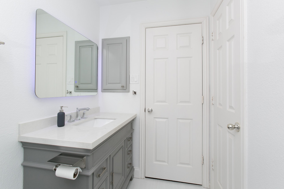 Источник вдохновения для домашнего уюта: маленькая ванная комната в стиле модернизм с фасадами с декоративным кантом, серыми фасадами, душем в нише, раздельным унитазом, черной плиткой, керамогранитной плиткой, белыми стенами, полом из керамогранита, душевой кабиной, врезной раковиной, столешницей из искусственного кварца, белым полом, душем с распашными дверями и белой столешницей для на участке и в саду