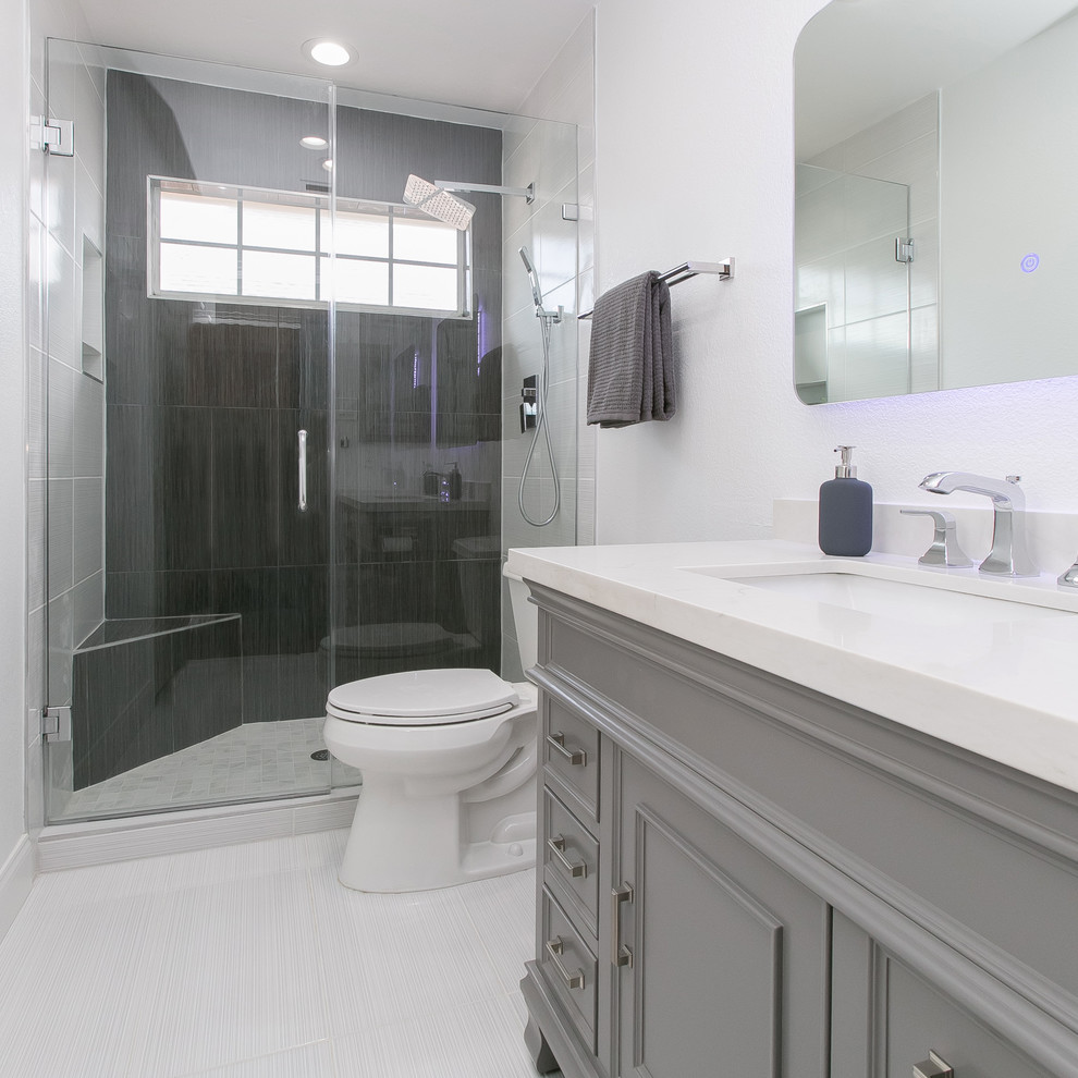 Small minimalist 3/4 black tile and porcelain tile porcelain tile and white floor alcove shower photo in Dallas with gray cabinets, quartz countertops, white countertops, a two-piece toilet, white walls, an undermount sink, a hinged shower door and recessed-panel cabinets