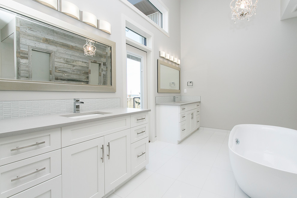 Medium sized contemporary ensuite bathroom in Calgary with shaker cabinets, a freestanding bath, a one-piece toilet, glass tiles, porcelain flooring, a submerged sink and solid surface worktops.