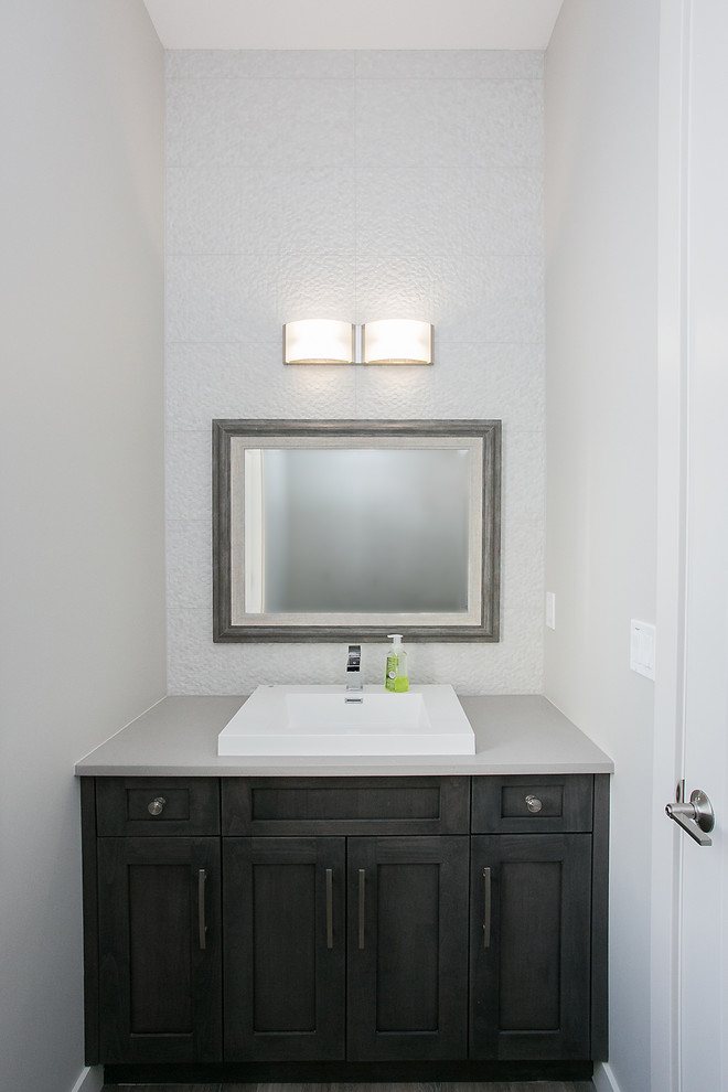 This is an example of a medium sized contemporary ensuite bathroom in Calgary with shaker cabinets, dark wood cabinets, a one-piece toilet, grey walls, dark hardwood flooring, a built-in sink and solid surface worktops.