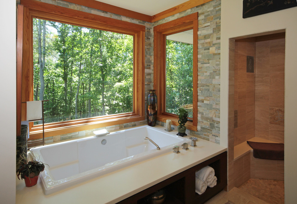Cette image montre une salle de bain design avec une baignoire posée, un carrelage multicolore et un mur blanc.