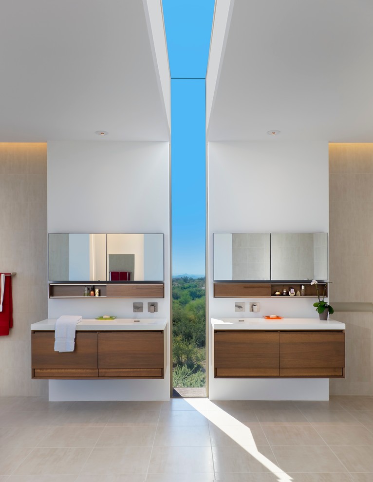 Modelo de cuarto de baño principal actual con lavabo integrado, armarios con paneles lisos, puertas de armario de madera oscura y paredes blancas