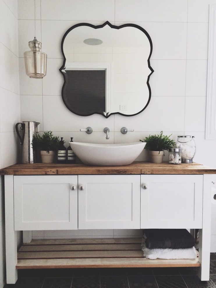 Esempio di una stanza da bagno contemporanea con ante con riquadro incassato, ante bianche, piastrelle bianche, top in legno, pavimento nero e top marrone