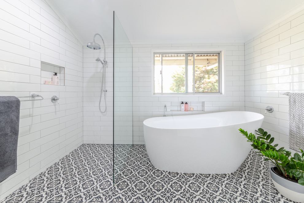 На фото: главная ванная комната среднего размера в стиле кантри с отдельно стоящей ванной, открытым душем, белой плиткой, керамической плиткой, белыми стенами, полом из керамической плитки, разноцветным полом и открытым душем