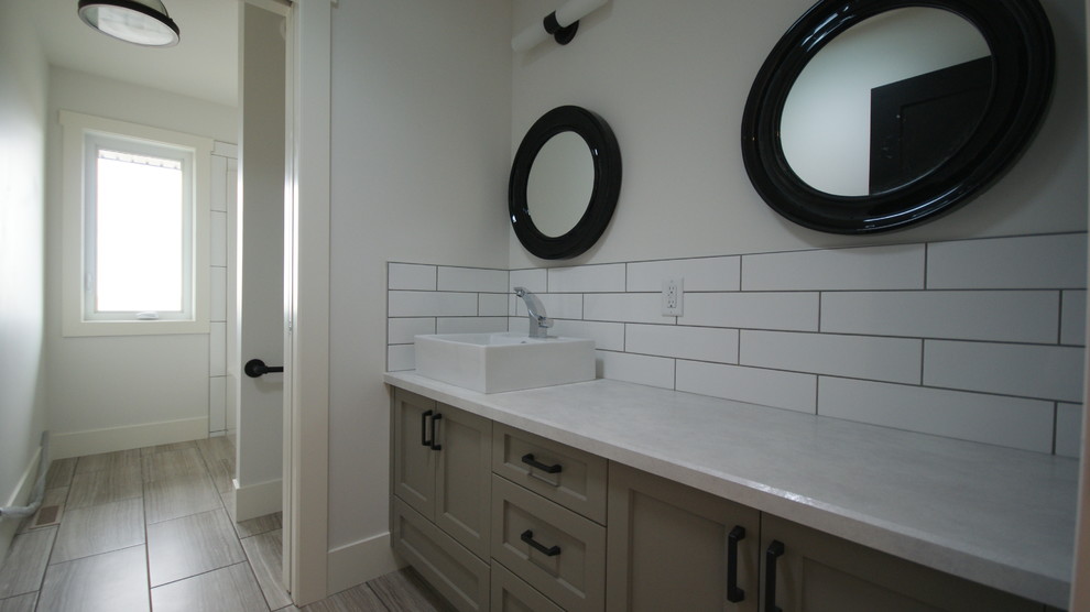 Immagine di una stanza da bagno contemporanea di medie dimensioni con lavabo da incasso, ante con riquadro incassato, ante grigie, top in granito, piastrelle bianche, piastrelle in ceramica, pareti bianche e pavimento con piastrelle in ceramica