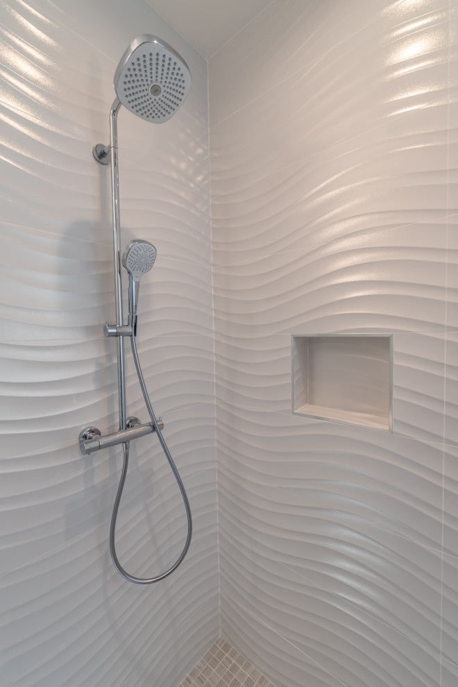 Example of a large minimalist 3/4 white tile and porcelain tile porcelain tile and gray floor alcove shower design in San Francisco with flat-panel cabinets, white cabinets, a one-piece toilet, gray walls, an undermount sink, quartz countertops, a hinged shower door and white countertops
