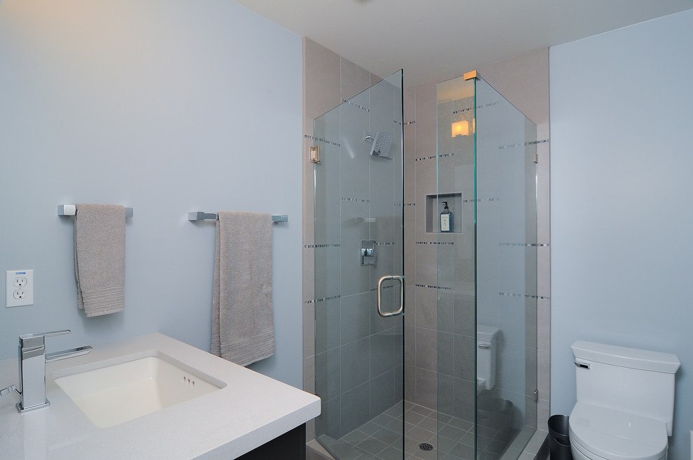Aménagement d'une salle de bain moderne avec un lavabo encastré, une douche d'angle et un carrelage beige.