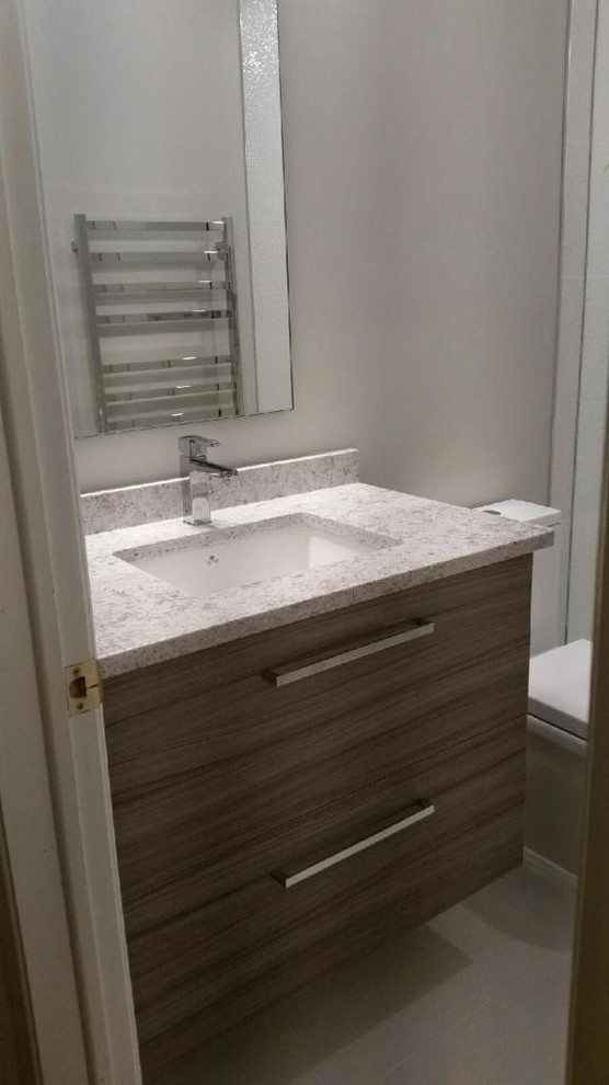 Inspiration for a mid-sized contemporary 3/4 porcelain tile alcove shower remodel in Toronto with flat-panel cabinets, medium tone wood cabinets, a two-piece toilet, gray walls, an undermount sink and marble countertops