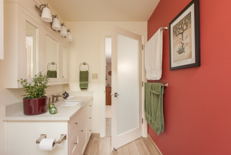 Kleines Rustikales Badezimmer mit weißen Schränken, offener Dusche, Toilette mit Aufsatzspülkasten, weißen Fliesen, Porzellanfliesen, roter Wandfarbe, Keramikboden, integriertem Waschbecken, Granit-Waschbecken/Waschtisch, beigem Boden und Falttür-Duschabtrennung in Portland