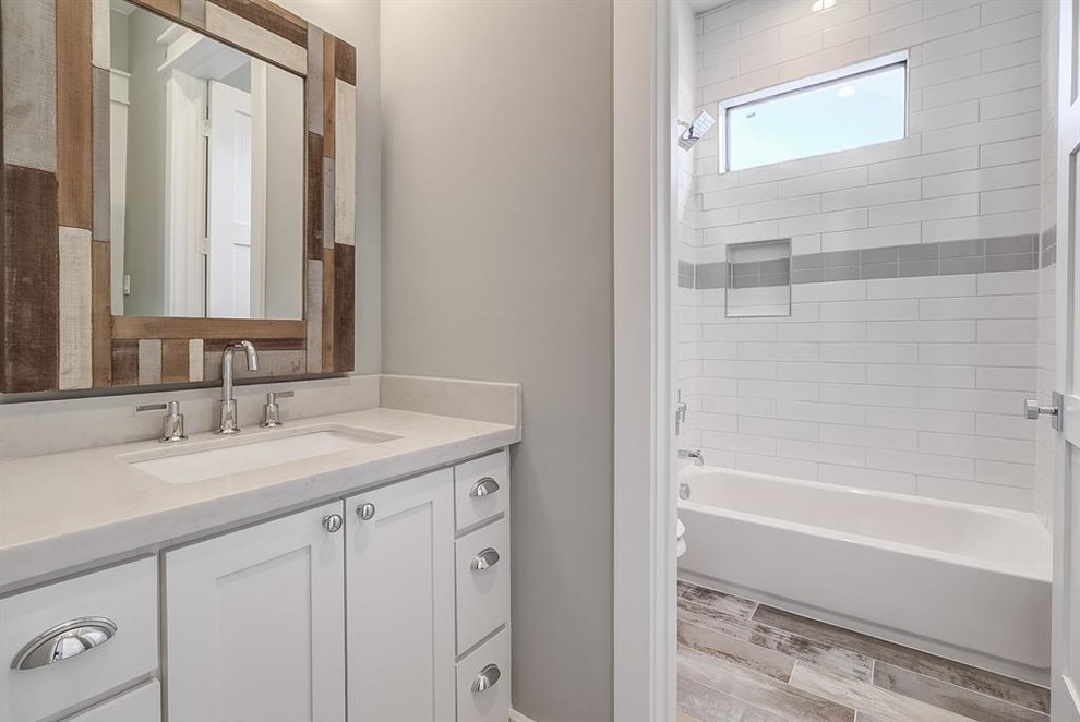 Foto på ett mellanstort amerikanskt vit badrum med dusch, med marmorkakel, grå väggar, klinkergolv i porslin, ett undermonterad handfat, beiget golv, skåp i shakerstil, vita skåp, ett badkar i en alkov, en dusch/badkar-kombination och vit kakel