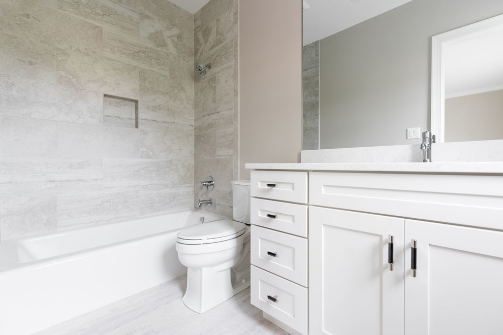 Inspiration for a mid-sized craftsman white tile and porcelain tile porcelain tile and white floor bathroom remodel in Other with white cabinets, shaker cabinets, a two-piece toilet, gray walls, an undermount sink and quartz countertops