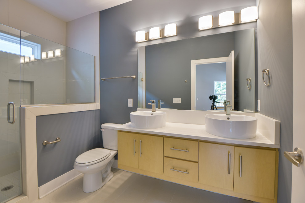 Idéer för ett litet modernt en-suite badrum, med släta luckor, skåp i ljust trä, bänkskiva i kvartsit, vit kakel, porslinskakel, ett fristående handfat, en öppen dusch, en toalettstol med separat cisternkåpa, blå väggar och klinkergolv i porslin