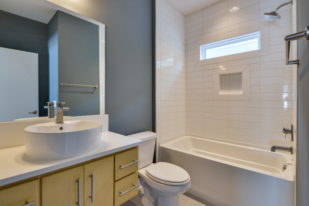 Inspiration for a small modern 3/4 white tile and porcelain tile porcelain tile drop-in bathtub remodel in Nashville with a vessel sink, flat-panel cabinets, light wood cabinets, quartzite countertops, a two-piece toilet and blue walls