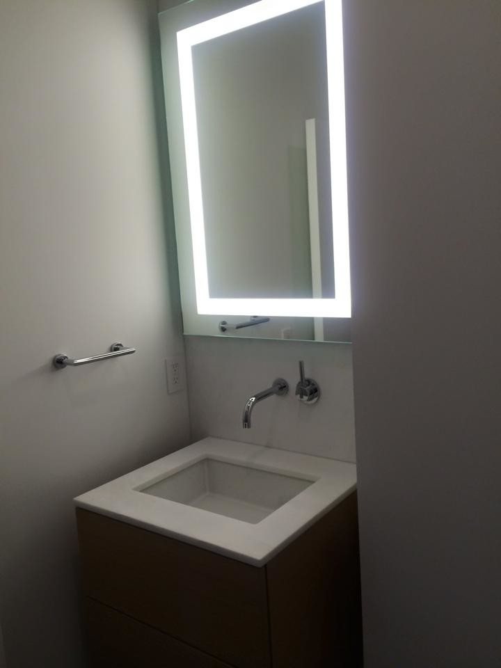 Esempio di una piccola stanza da bagno minimalista con ante lisce, ante nere, pareti bianche, lavabo sottopiano, top in quarzite e top bianco